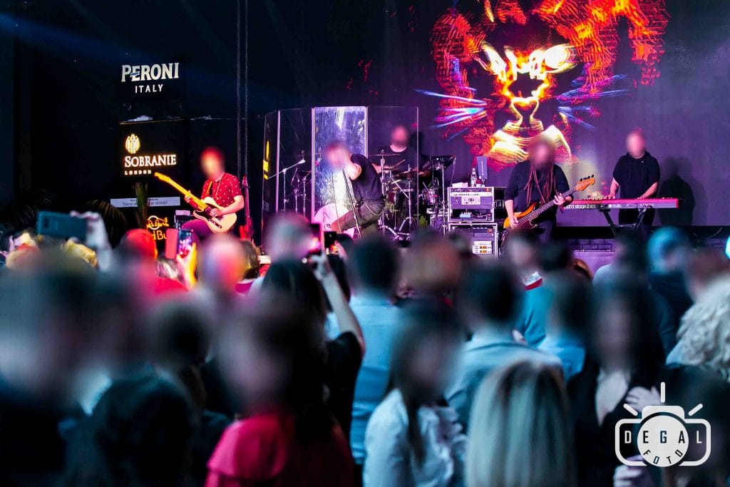 Trupă cântând pe scenă, cu public la petrecere corporate în față surprins de fotograf Alin Gavrila la concert